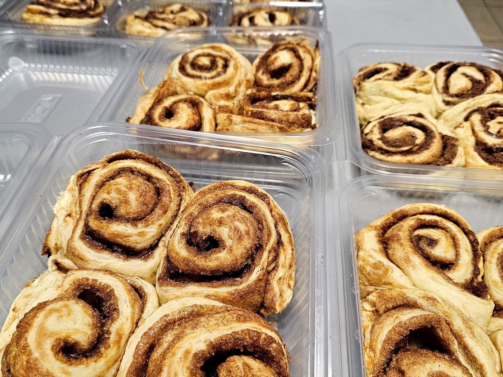 Fresh cinnamon roll four-packs boxed up and ready to share, gift, or enjoy all to yourself. Just waiting on the icing!