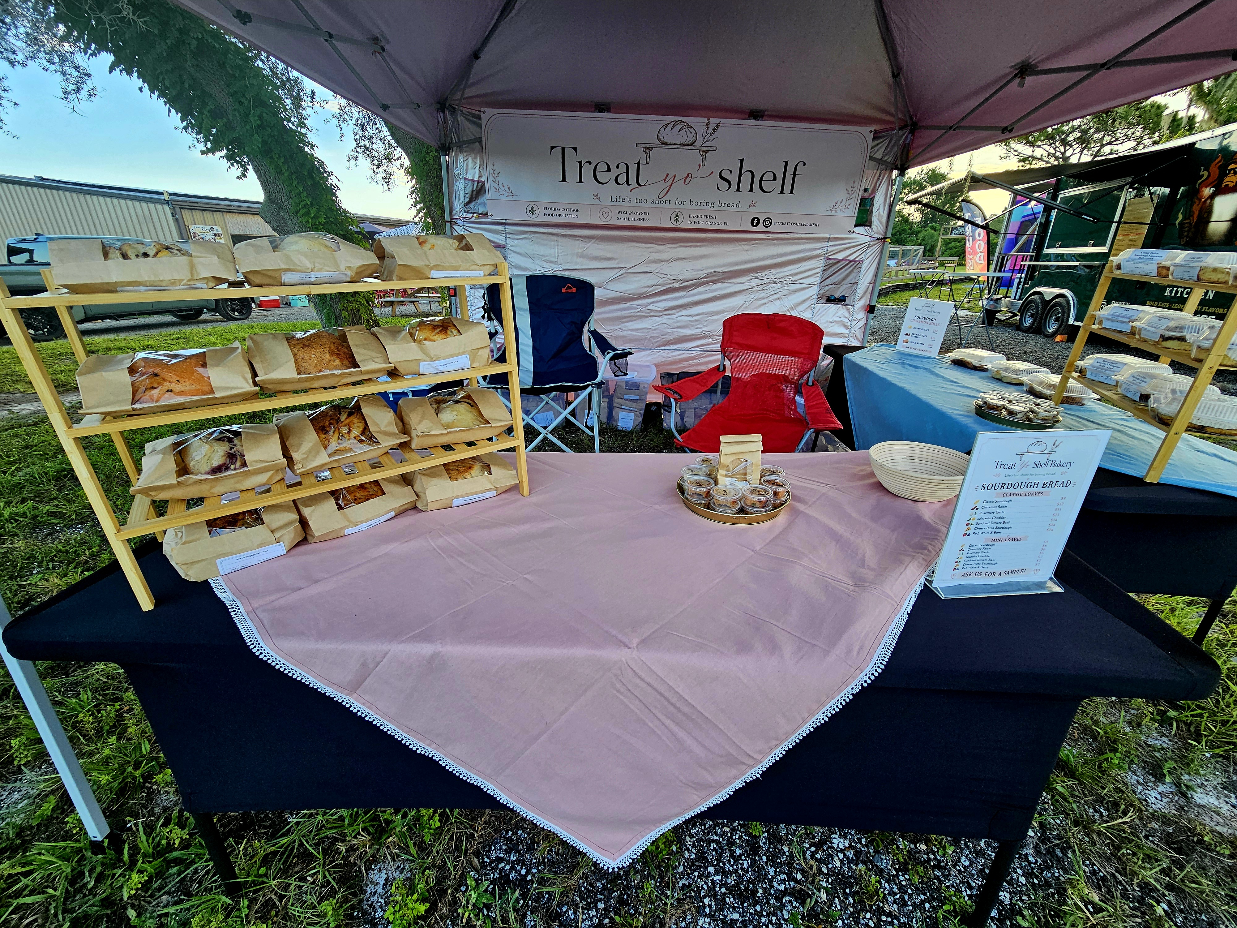 Fresh sourdough loaves and bakery items displayed at the Treat Yo’ Shelf Bakery booth.